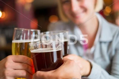 People with beer toasting in a pub Stock Photos