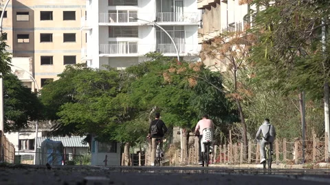 People on bicycles ride through ghost town Varosha, Famagusta Cyprus Stock Footage 237517267