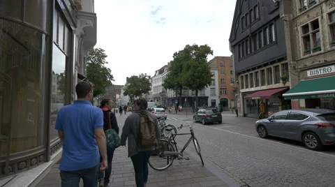 People biking and walking and cars driving on Vlamingstraat, Bruges Stock Footage 59658658