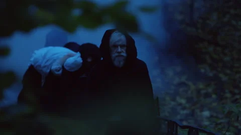 People in black carrying a corpse Stock Footage 283183774