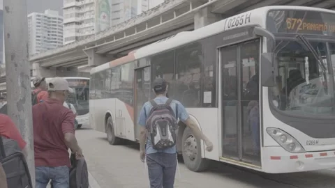 People boarding a bus at a bus stop in Panama Stock Footage 343747240