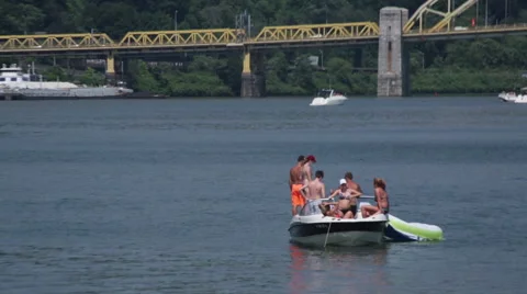 People boating in the river in front of a yellow bridge in Pittsburgh Stock Footage 64894294