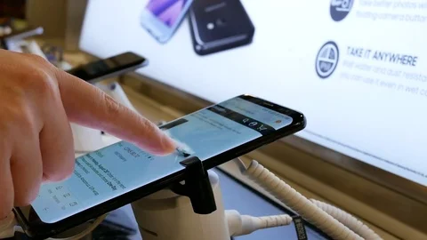 People browsing amazon on Samsung Galaxy S8 cellphone at store Video stock 80182871