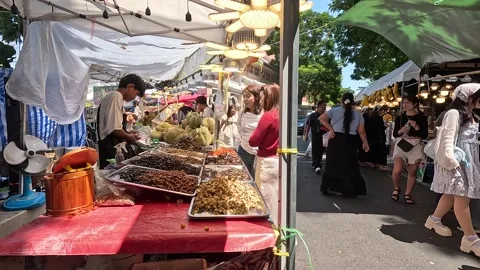 People Browsing Fried Insect Food Stalls at Outdoor Asian Market Stock Footage 346266990
