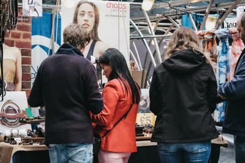 People browsing items at stalls inside Spitalfields Market, London, UK. Stock Photos
