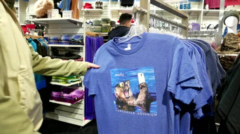 People buying Vancouver aquarium logo T-shirt inside gift shop. Stock Footage