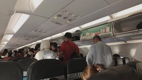 People can be seen queuing to disembark from the airplane. 動画素材 300979164