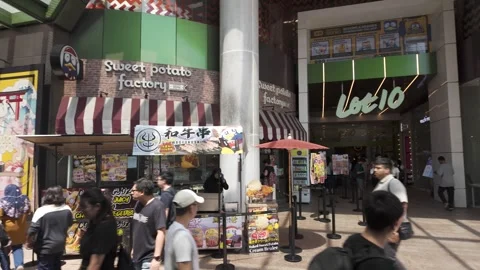 People can seen exploring in front of the Lot 10 shopping centre 動画素材 275833756