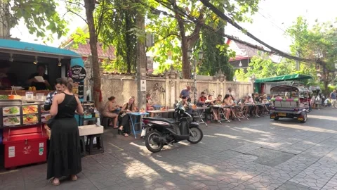 People can seen having their food along the roadside in Khao San Road. Видео 314214477