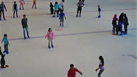 People can seen playing ice skating at a public ice skating rink. Видео 79550826