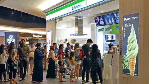 People can seen queuing in front of the FamilyMart to buy foods. Видео 116410882