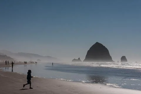 People on Cannon Beach with Haystack Rock, Oregon, USA Stock Photos