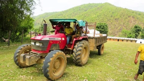 People carrying bunch of objects on a tractor Stock Footage 77444389