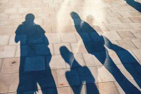 People casting shadows on the pavement Stock Photos
