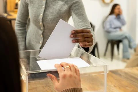 People casting votes into a ballot box Stock Photos