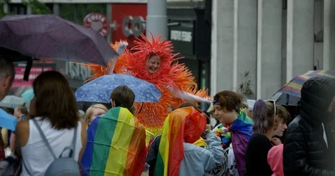 People Celebrating Pride Parade With Rainbow Flags Umbrellas and Signs  Stock Footage 113520583