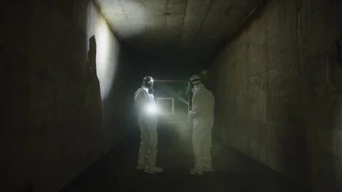People in Chemical Suits With Flashlights Exploring the Underground Stock Footage 240111628