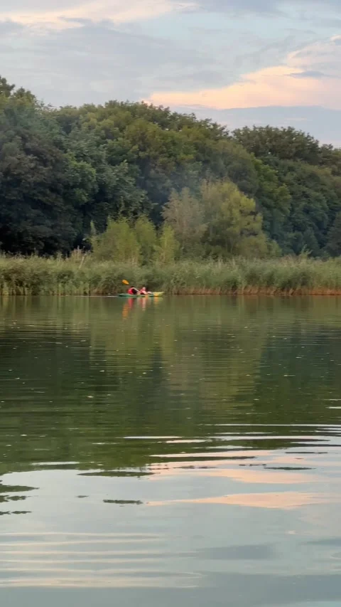 People chilling on the lake on sunset Stock Footage 252179090
