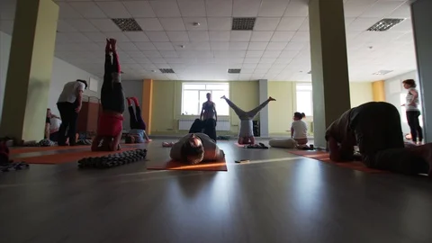 People in classrom do different yoga asanas on hands or heads Video stock 120151790