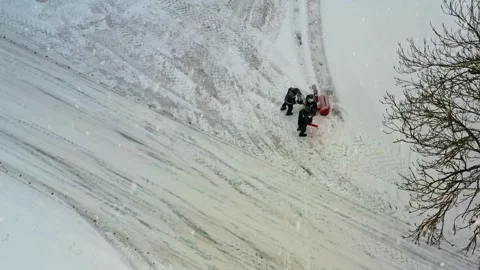 People clearing snow with a snow thrower machine during a heavy winter snowfall Stock Footage 345695218