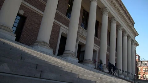 People climb steps to enter a big classic building with columns Stock Footage 77378783