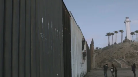 People Climbing The Border Wall Stock Footage 100567974