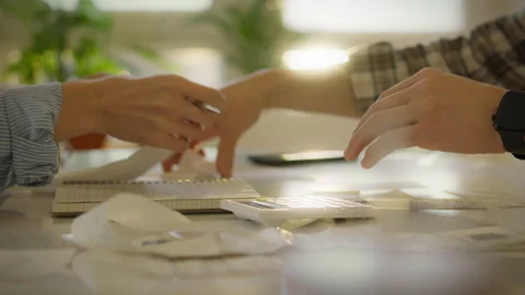 People collaborating on financial planning during daylight in a cozy workspa Stock Footage 323868512