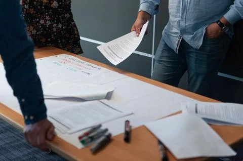 People Collaborating at a Table with Documents and Markers Foto stock