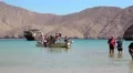 People come out of the boat to the shore of Musandam peninsula, Oman HD Footage