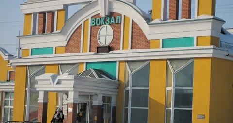 People come out of the multi-colored building of the town railway station . Vídeos de archivo 233586779