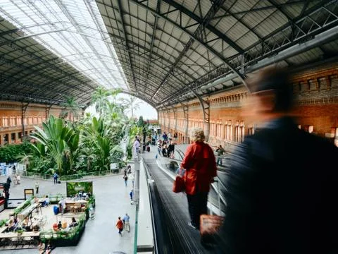 People commuting and walking inside Atocha train station in Madrid Stock Photos