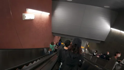 People commuting and walking through a modern underground metro station Stock Footage 330010404