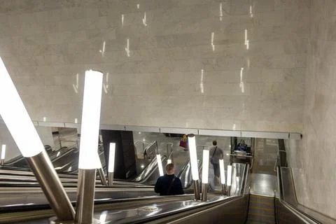 People commuting on escalators in a modern underground metro station Stock Photos