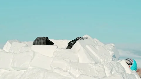 People construct igloo with white snow blocks on frozen sea Stock Footage 133819268