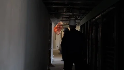 People in construction helmets go on a construction site. Businessmen inspect Stock Footage 125034973