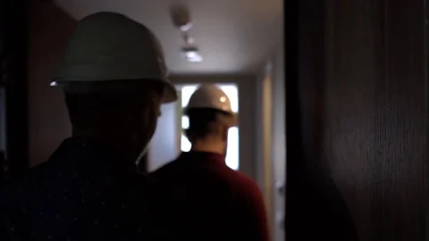 People in construction helmets go on a construction site. Businessmen inspect Stock Footage 125035034