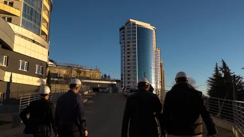 People in construction helmets go on a construction site. Businessmen inspect Stock Footage 125035084