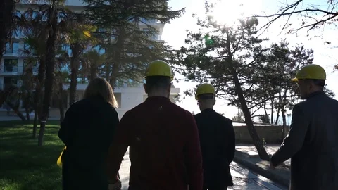 People in construction helmets go on a construction site. Businessmen inspect Stock Footage 125035246