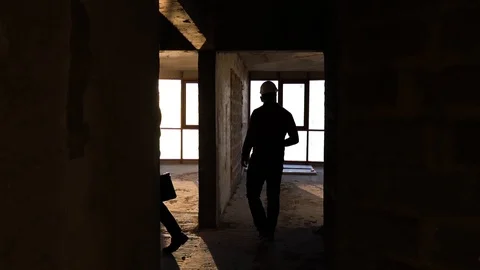 People in construction helmets go on a construction site. Businessmen inspect Stock Footage 125035271