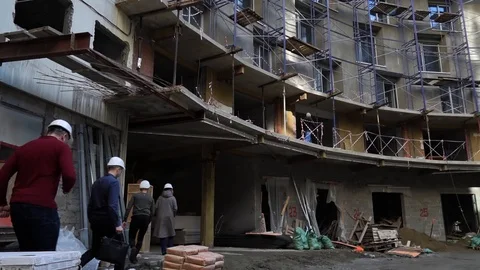 People in construction helmets go on a construction site. Businessmen inspect Stock Footage 125035300