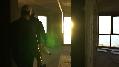 People in construction helmets go on a construction site. Businessmen inspect Stock Footage 125035327