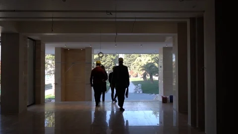People in construction helmets go on a construction site. Businessmen inspect Stock Footage 125035348