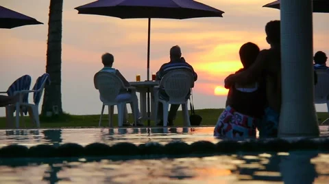People / couple watching sunset in a pool in a tropical resort Stock Footage 60259769