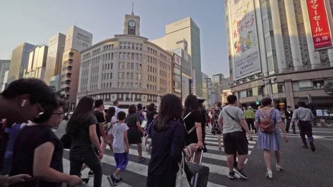 People cross the street at an intersection in the Ginza district, Tokyo. Stock Footage 112259743