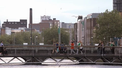 People crossing by a bridge over the River Liffey Stock Footage 101643218