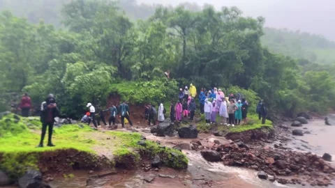 People crossing a flooded stream during a monsoon landslide Vídeos de archivo 341797612