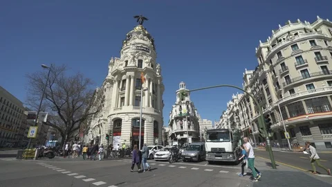 People crossing the Gran Via street to Edificio Metropolis in central Madrid. 库存影片 90780776