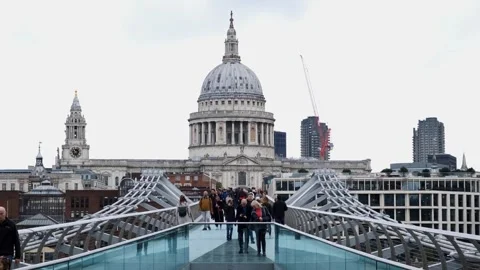 People crossing the Millenium bridge. St Paul's Cathedral backdrop. London 스톡 동영상 289847241