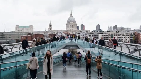 People crossing the Millenium bridge. St Paul's Cathedral backdrop. London Stock Footage 289847254