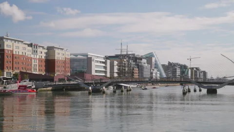 People crossing the Millenium Pedestrian Bridge, Dublin Ireland, over the River 库存影片 320395724